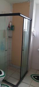a shower with a glass door in a bathroom at Aconchego in Marituba