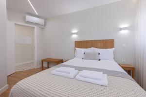 a bedroom with a large bed with two white pillows at Modern 2BR Apt with Patio and AC in Lisbon
