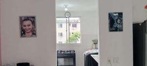 a kitchen with two pictures on the wall and a clock at Aconchego in Marituba