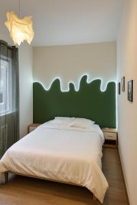 a bedroom with a large bed with a green headboard at Chambre privée "verte" - Maison partagée in Amiens +5 photos