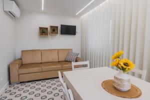 a living room with a table and a couch at Modern 2BR Apt with Patio and AC in Lisbon