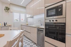 a kitchen with a large oven and a sink at Modern 2BR Apt with Patio and AC in Lisbon +27 photos