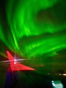 a view of the northern lights from an airplane at Central studio apartment in Tromsø