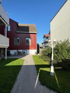 a pathway between two buildings with a red house and a lamp at Central studio apartment in Tromsø