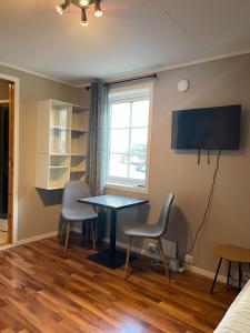 a room with a table and chairs and a window at Central studio apartment in Tromsø +6 photos
