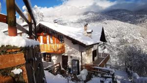 a house covered in snow in the mountains at Villa Meledrio in Dimaro