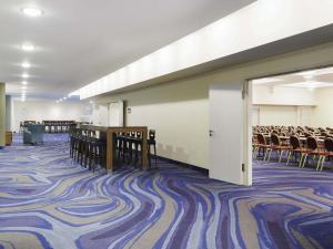 an empty room with chairs and tables and a corridor at Mercure Hotel Berlin Tempelhof in Berlin