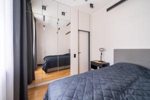 a bedroom with a bed and a mirror at Premium One Bedroom Apartment Dzintari Beach & Park in Jūrmala