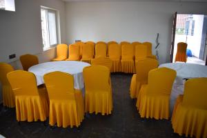 a room with yellow chairs and tables in a room at Hotel Skyview in Kondapur