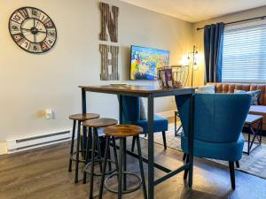 une table à manger et des chaises avec une horloge sur le mur dans l'établissement NEW - Mins to Manchester - Concord - Riverfront, à Hooksett