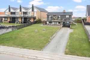 una casa grande con un patio de hierba delante de ella en 70794-Ulfborg-Skolegade-17, en Thorsminde