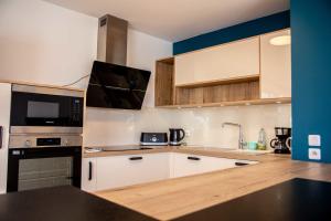 a kitchen with white cabinets and black appliances at spacious and bright apartment in Bordeaux