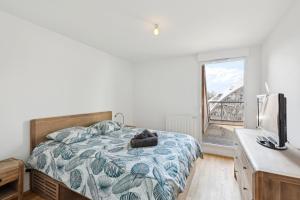 a bedroom with a bed and a television and a window at spacious and bright apartment in Bordeaux