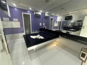 a room with a bed with a mirror and purple walls at Pousada La Ñina in Belém +4 photos