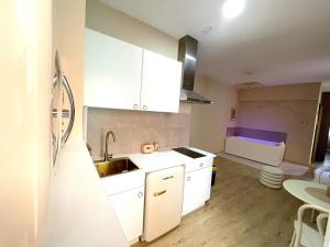 a kitchen with white cabinets and a sink at Les 1001 nuits in Albi