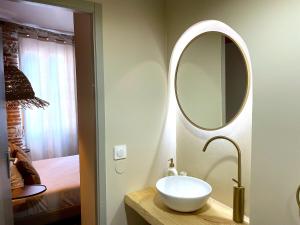 a bathroom with a white sink and a mirror at Les 1001 nuits in Albi +1 photo