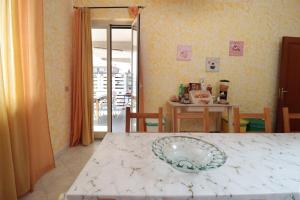 a dining room with a table with a plate on it at Appartamento Le Palme Tra Taormina e Catania in Linera