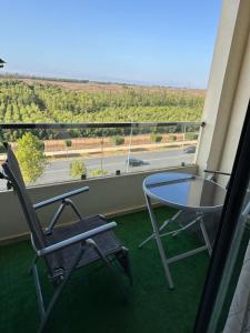 - Balcón con mesa de cristal y 2 sillas en Beautiful apartment with a beautiful view, en Kenitra