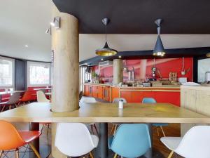 a kitchen with a large wooden table and chairs at ibis Paris Brancion Parc des Expositions 15ème in Paris