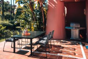 Un patio con mesa y sillas y parrilla. en Luxury Sea View Oasis EHHouse, en Estepona