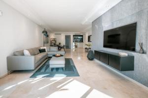 Una sala de estar con un sofá y un televisor de pantalla plana. en Luxury Sea View Oasis EHHouse, en Estepona