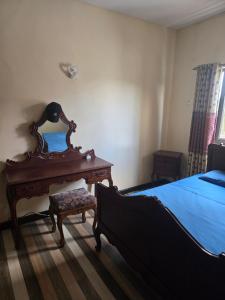 a bedroom with a bed and a wooden table and a bed sidx sidx at Chambre et SDB privées in Flic-en-Flac