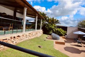 a house with a stone wall and a patio at Hotel Village Premium Caruaru in Caruaru