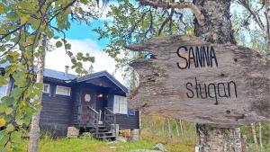 a sign on a tree in front of a house at Messlingen, Orrstigen 16 in Funäsdalen