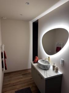 a bathroom with a sink and a large mirror at The Ponote Escape in Le Puy en Velay