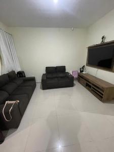Una sala de estar con un sofá y un televisor de pantalla plana. en Residencial Day off, en Guaratuba