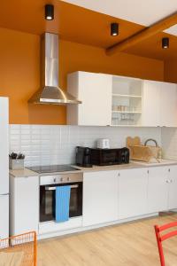 Una cocina con gabinetes blancos y un horno de estufa. en Chambre privée "bleue" - Salle de bain privative, en Amiens
