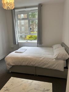 a bed in a room with a large window at Don Jackson London Apartment in London