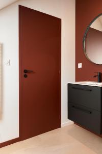 baño con puerta marrón y lavamanos en Chambre privée "bleue" - Salle de bain privative, en Amiens