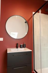 un baño con lavabo y espejo en Chambre privée "bleue" - Salle de bain privative, en Amiens