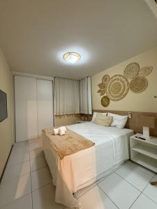 a bedroom with a bed with a cat laying on it at Iloa resort AP luxo in Barra de São Miguel