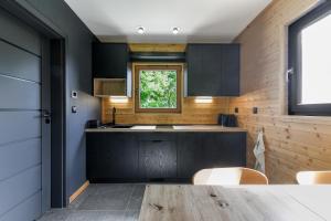 a kitchen with a table and a window at Domki Salamandra Lipowa in Lipowa