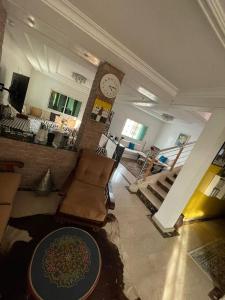 a living room with a couch and a clock on a wall at Triplex of art and serenity in Kouas +11 photos