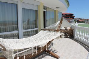 eine Hängematte auf dem Balkon eines Hauses in der Unterkunft Семеен Хотел Идън in Sweti Wlas