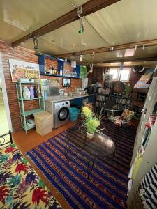 a living room with a rug on the floor and a kitchen at Triplex of art and serenity in Kouas