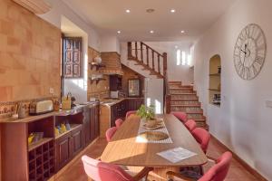 a kitchen with a wooden table and red chairs at Holiday House Dehesa del Colmenar in Cabra