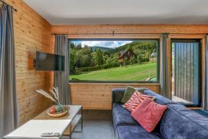 a living room with a couch and a large window at Domki Salamandra Lipowa in Lipowa