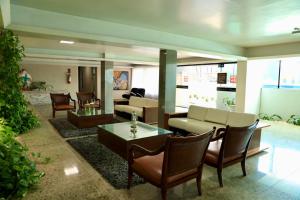a lobby with couches and a table and chairs at Hotel Village Premium Caruaru in Caruaru