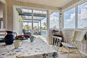 een eetkamer met een tafel, stoelen en ramen bij SB119-Sydals-Mollebakken-9 in Sønderby
