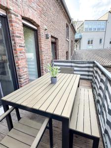 a wooden table and bench on a balcony at Beautiful Apartment Köln 15 Min to Phantasialand in Hürth