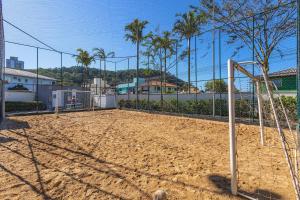 a volleyball court with a net on a dirt field at Residencial Lunata | 200m da praia | Penha in Penha