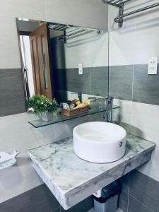 a bathroom with a sink and a mirror at The Sun Hotel in Long Bình