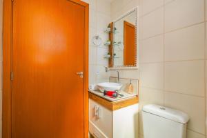 an orange door in a bathroom with a toilet at Residencial Lunata | 200m da praia | Penha in Penha +22 photos