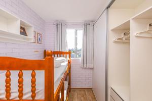 a small bedroom with a bed and a window at Residencial Lunata | 200m da praia | Penha in Penha