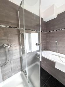 a bathroom with a shower and a bath tub at Beautiful Apartment Köln 15 Min to Phantasialand in Hürth