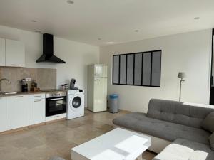 a living room with a couch and a kitchen at Le Prestige - Spacieux T3 Neuf et Lumineux in Évreux